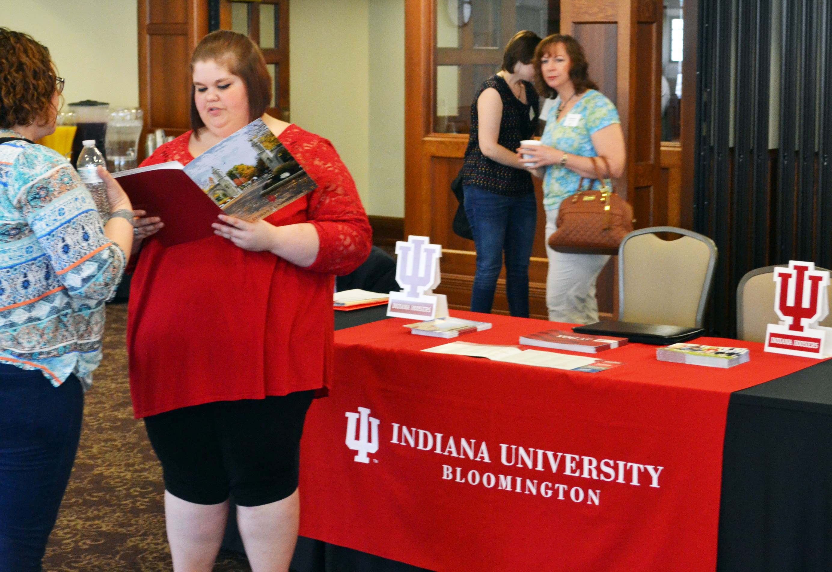 A woman reads about the benefits of the 21st Century Scholar program in a brochure.